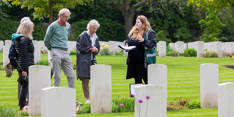 Tourgoers in a CWGC graveyard attending a talk.